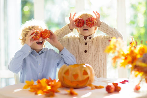 Family carving pumpkin for Halloween Family carving pumpkin for Halloween celebration. Boy and girl child cutting jack o lantern for traditional trick or treat decoration. Kids decorate home. Children carve pumpkin. Spooky Halloween fun. 24407 stock pictures, royalty-free photos & images