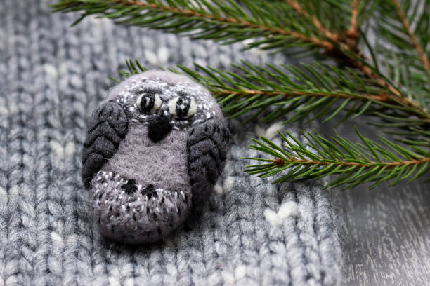 Handmade wool brooch on a sweater background. Selective focus, rustic style.