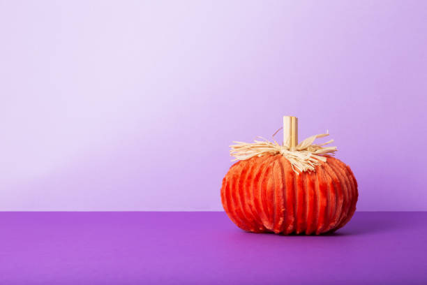 istock Halloween celebration. Decorative soft pumpkin on  purple background 1342282078