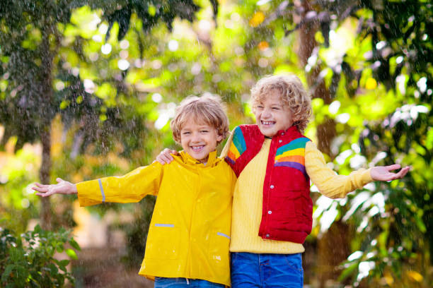 istock Child playing in autumn rain. Kid with umbrella. 1342283755