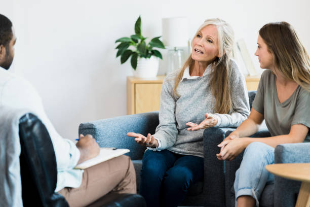 istock Mother looks at therapist while talking as daughter watches 1342284432