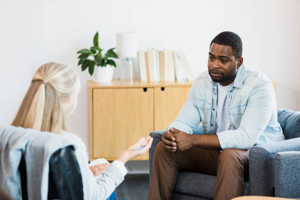 istock Sad, hopeless male client listens to unrecognizable counselor 1342284447