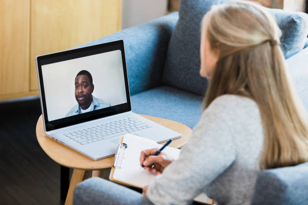 istock Female therapist takes notes as man shares on video call 1342284462