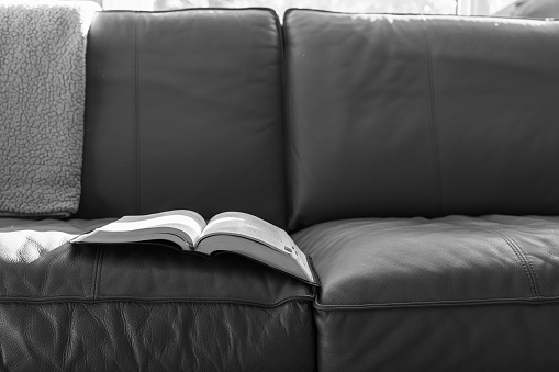 Open bible laying on couch with blanket and morning light with copy space