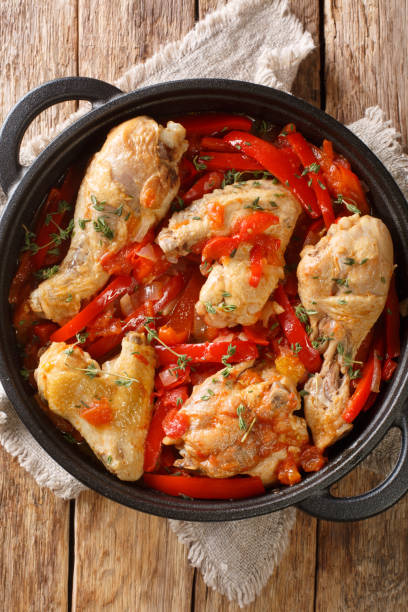 istock Basque chicken stew with bell peppers, onions and tomatoes close-up in a pan on the table. vertical top view 1342289971