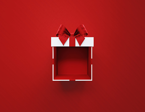 Open white gift box tied with red ribbon on red background. Horizontal composition with copy space. Directly above. Great use for Christmas and Valentine's Day related gift concepts.