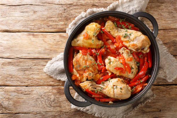 Basque Braised Chicken with Peppers Poulet Basquaise close up in the pan. Horizontal top view Basque Braised Chicken with Peppers Poulet Basquaise close up in the pan on the table. Horizontal top view from above stew photos stock pictures, royalty-free photos & images