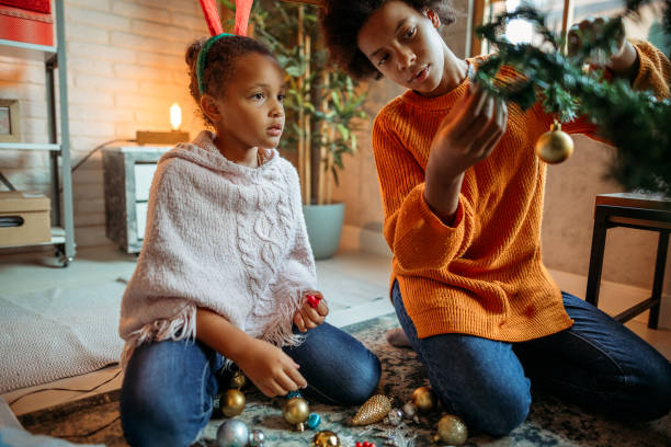 istock Two girls sisters in decorating Christmas tree at home 1342293786