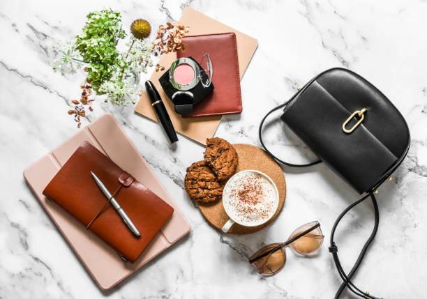 istock Women's office desk - notebooks, organizer, tablet, cappuccino cup and cookies with chocolate drops on a marble background, top view 1342294901
