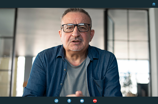 Senior man talking to webcam