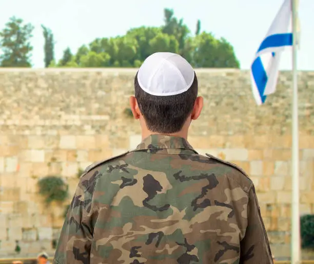 Photo of jewish soldier in front of the Western Wall