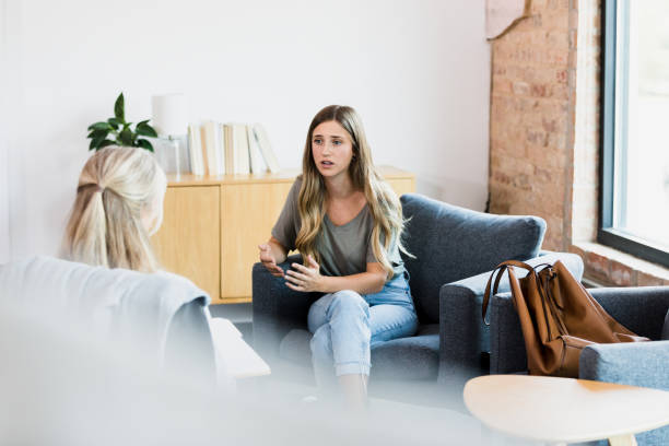 istock Vulnerable young woman talks with therapist 1342300640