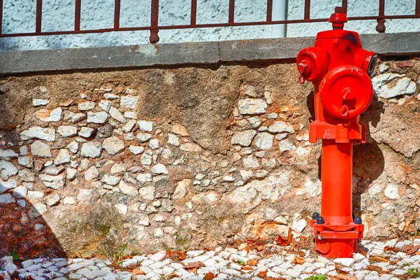 Closeup View of Old Styled Red Fire Cock Hydrant Against of Wall Located On One of The Streets in Portugal. Horizontal Image Composition