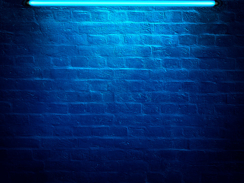 Dark brick wall lit by neon light. Vintage background