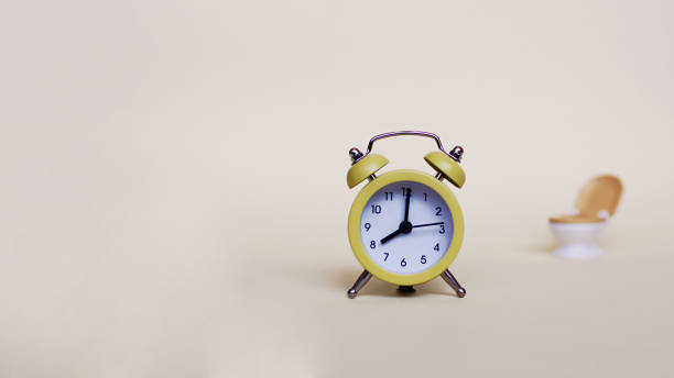 istock Yellow alarm clock and white toilette bowl 1342304587