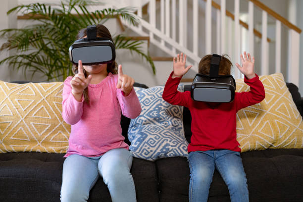 istock Happy caucasian siblings sitting on sofa, wearing vr headset and having fun 1342307786