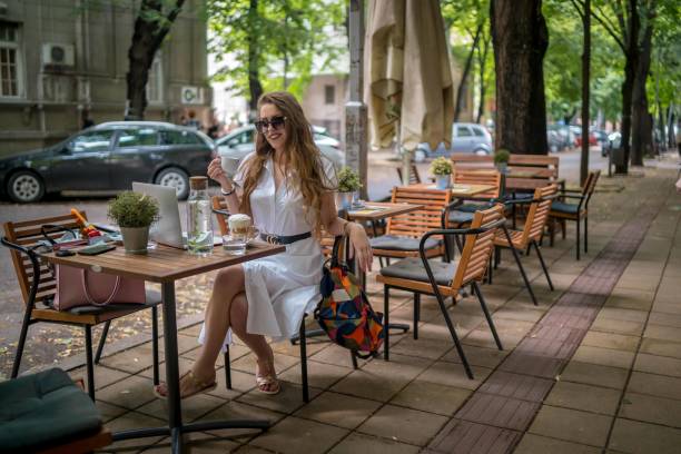 istock Businesswoman using laptop while enjoying work at cafe table with cup of coffee 1342309079