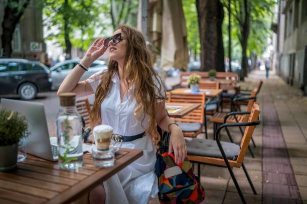 istock Businesswoman using laptop while enjoying work at cafe table with cup of coffee 1342309248