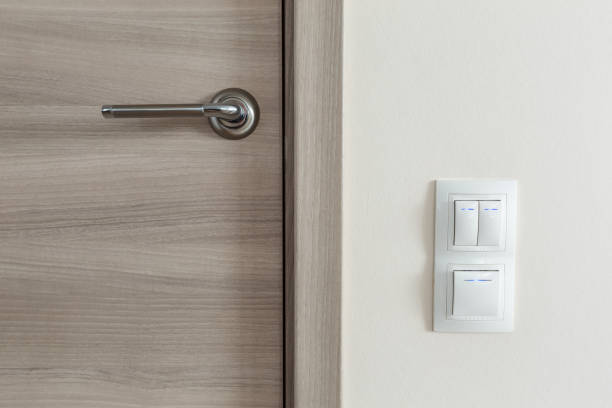 istock Door handle and white lighting switches on wall 1342315640