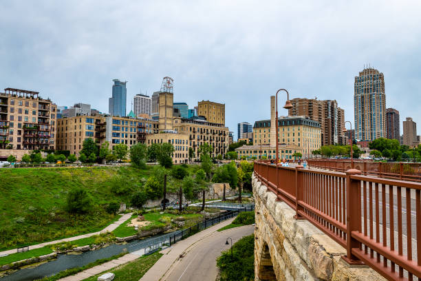 Photograph of the Mill District on the Mississippi River in Downtown Minneapolis through an arch of the Stone Arch Bridge