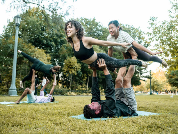 istock People practising Acro Yoga in the park 1342319036