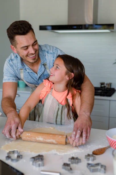 istock Happy caucasian father and daughter baking together, making cookies in kitchen 1342319065