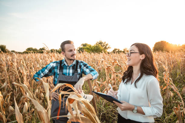 istock Farmer and business woman talking in corn field 1342321183