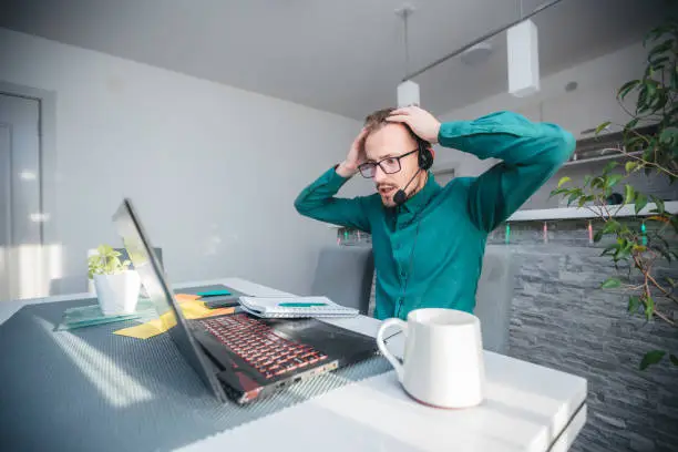 Photo of Young stressed handsome businessman working in office. Angry businessman with too much work in office.