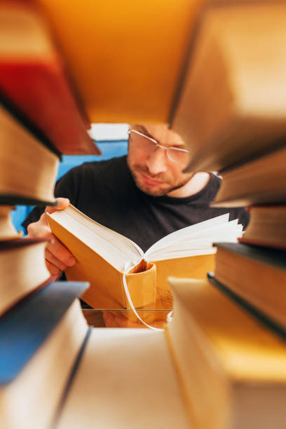 istock Frame from a pile of books - inside a middle-aged reading man with glasses 1342324270