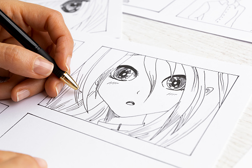El artista dibuja cómics de anime en papel. Guión gráfico para la caricatura. El ilustrador crea bocetos para el libro. photo