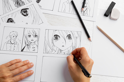The artist draws anime comics on paper. Storyboard for the cartoon. The illustrator creates sketches for the book. Manga style.