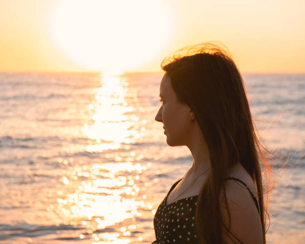 istock young woman looking at the sea while the sunrise 1342328742