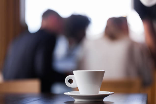 istock Coffee cup on a table in cafeteria. Group of people blurred in the background.. 1342336497