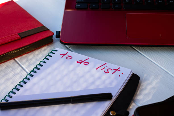 istock Notebook with To Do List with phone, red diary and laptop on a white wooden background. 1342343507