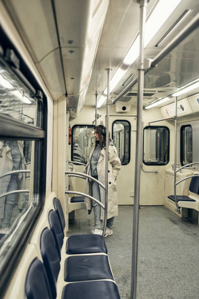 una chica con una gabardina beige viaja en un vagón del metro - 16611 fotografías e imágenes de stock