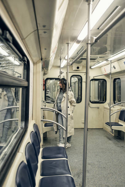 una ragazza in un trench beige viaggia in un vagone della metropolitana - 16611 foto e immagini stock
