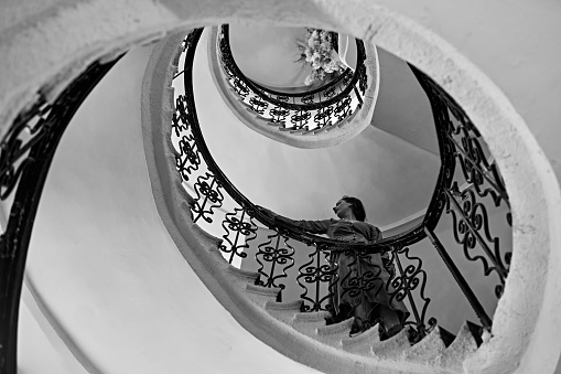Beautiful young girl on a spiral staircase. Vintage.