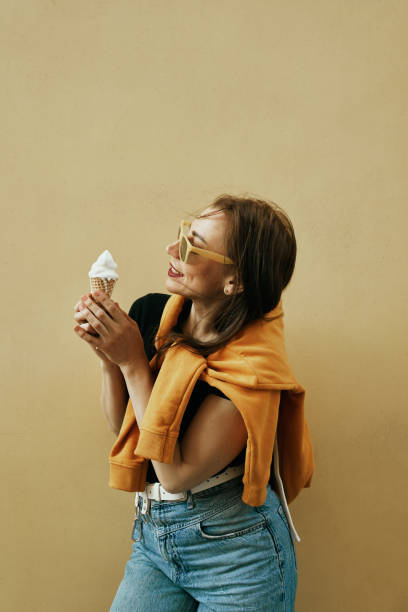 istock Summer background. Beautiful young girl eats ice cream. Colored background. 1342351845