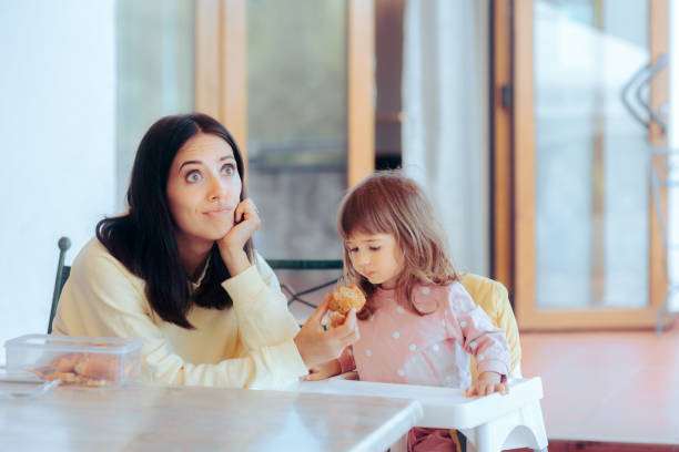 maman stressée essayant de nourrir sa fille en bas âge au restaurant - eating obsessive child toddler photos et images de collection