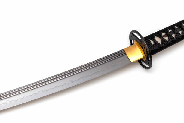 istock Japanese sword blade (made in China) on white background. Soft focus.  The wavy pattern on the blade edge is a line of hardness that a blacksmith makes so that the blade doesn't break. 1342367096