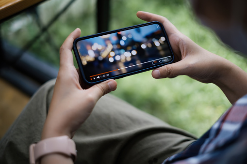 Mientras pone en cuarentena a una mujer viendo streaming en directo por aplicación en smartphone. photo