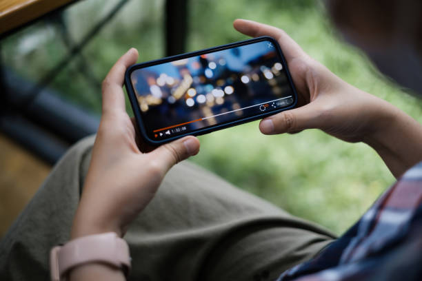 mientras pone en cuarentena a una mujer viendo streaming en directo por aplicación en smartphone. - television commercial fotografías e imágenes de stock