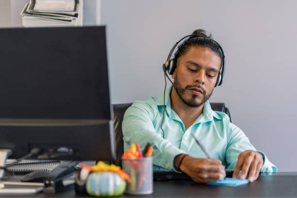 istock Latin man working in a office talking on the phone with a client 1342369483