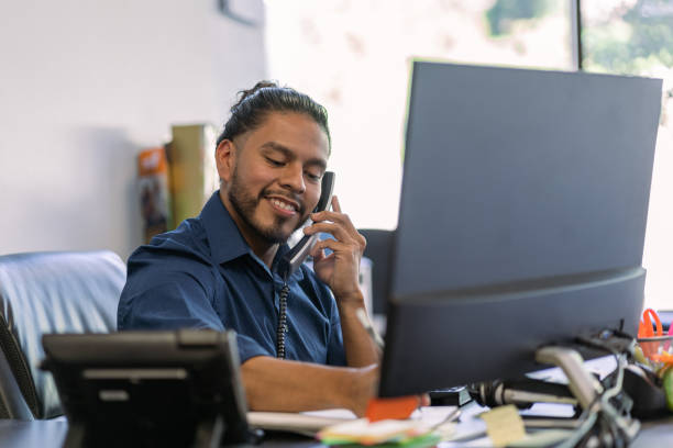 istock Latin man working in a office talking on the phone with a client 1342369539