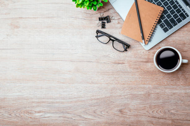 istock Work from home. desk office with laptop, blank notepad, coffee cup and pen on wood table. Flat lay top view copy spce. 1342371330