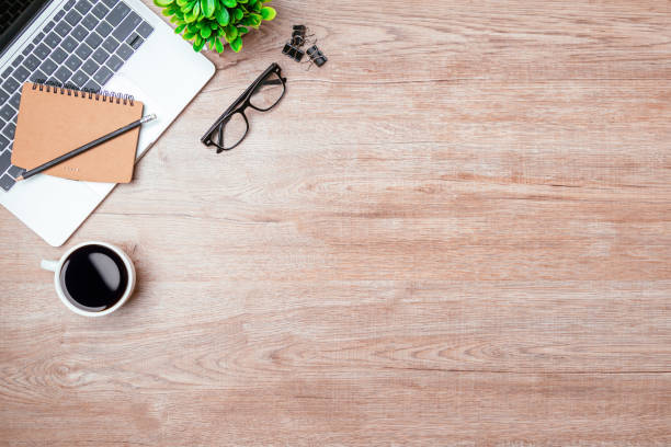 istock Work from home. desk office with laptop, blank notepad, coffee cup and pen on wood table. Flat lay top view copy spce. 1342371341