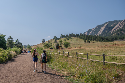 Boulder, CO - August 29, 2021: Young women go for a walk at the Chautauqua Park Hiking area.