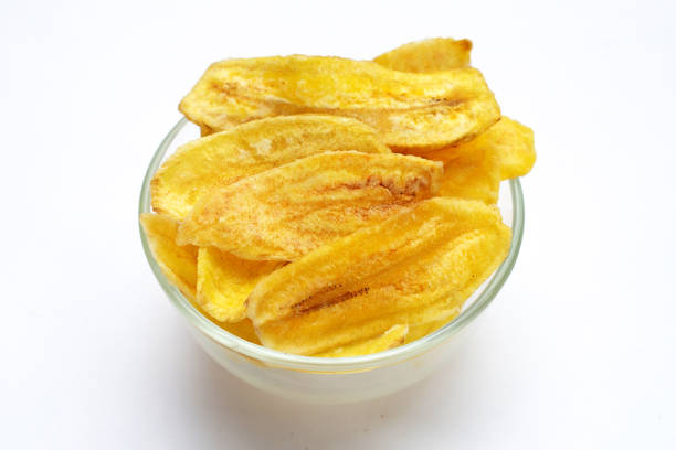 istock Banana slice chips in glass bowl on white background 1342378313