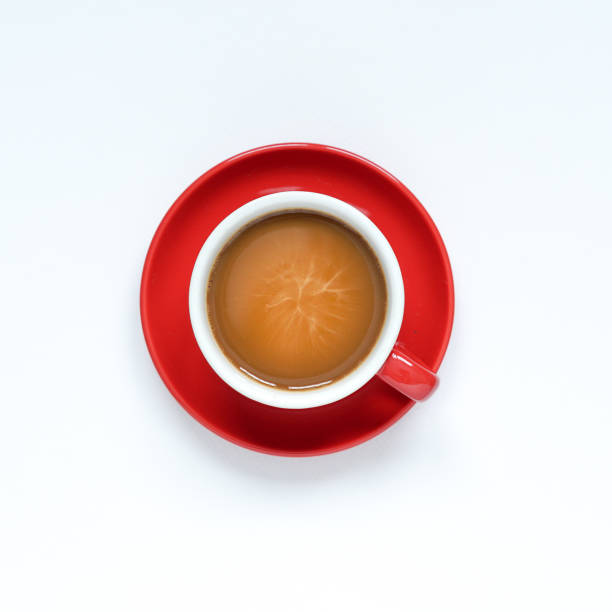 istock over a white background, a hot coffee cup in a circular red ceramic mug and a red ceramic plate 1342380059