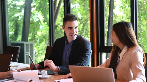 istock Handsome businessman working on project with colleagues in meeting room. 1342380249